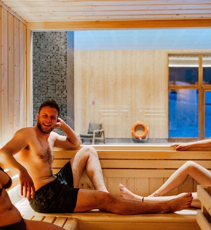 Smiling couple sitting in Bear Lodge sauna